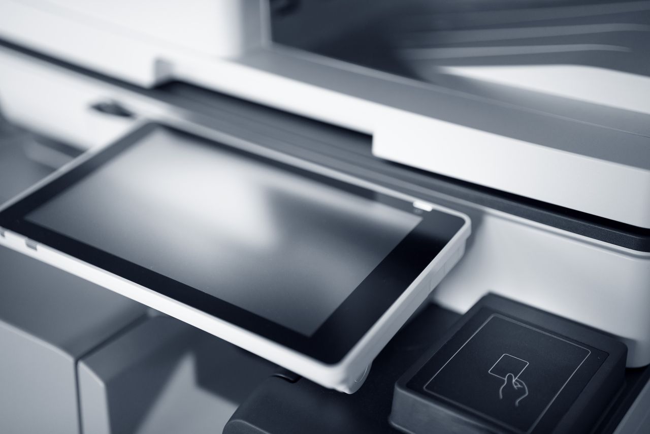 our-story Close-up of a modern printer with a touchscreen interface in a professional office setting.