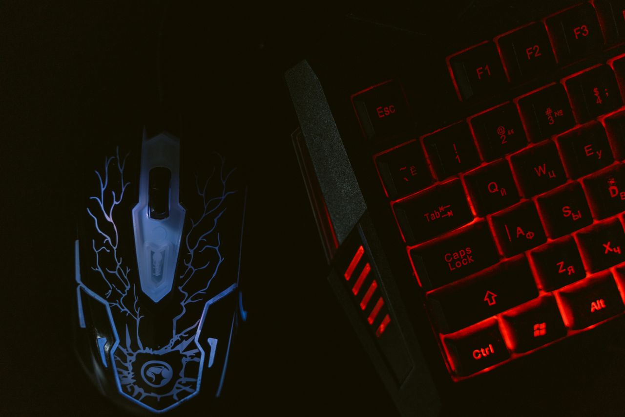 The Art of Drawing Readers In: Your attractive post title goes here Close-up of a glowing gaming mouse and a backlit keyboard in a dim setting, showcasing a tech-savvy setup.